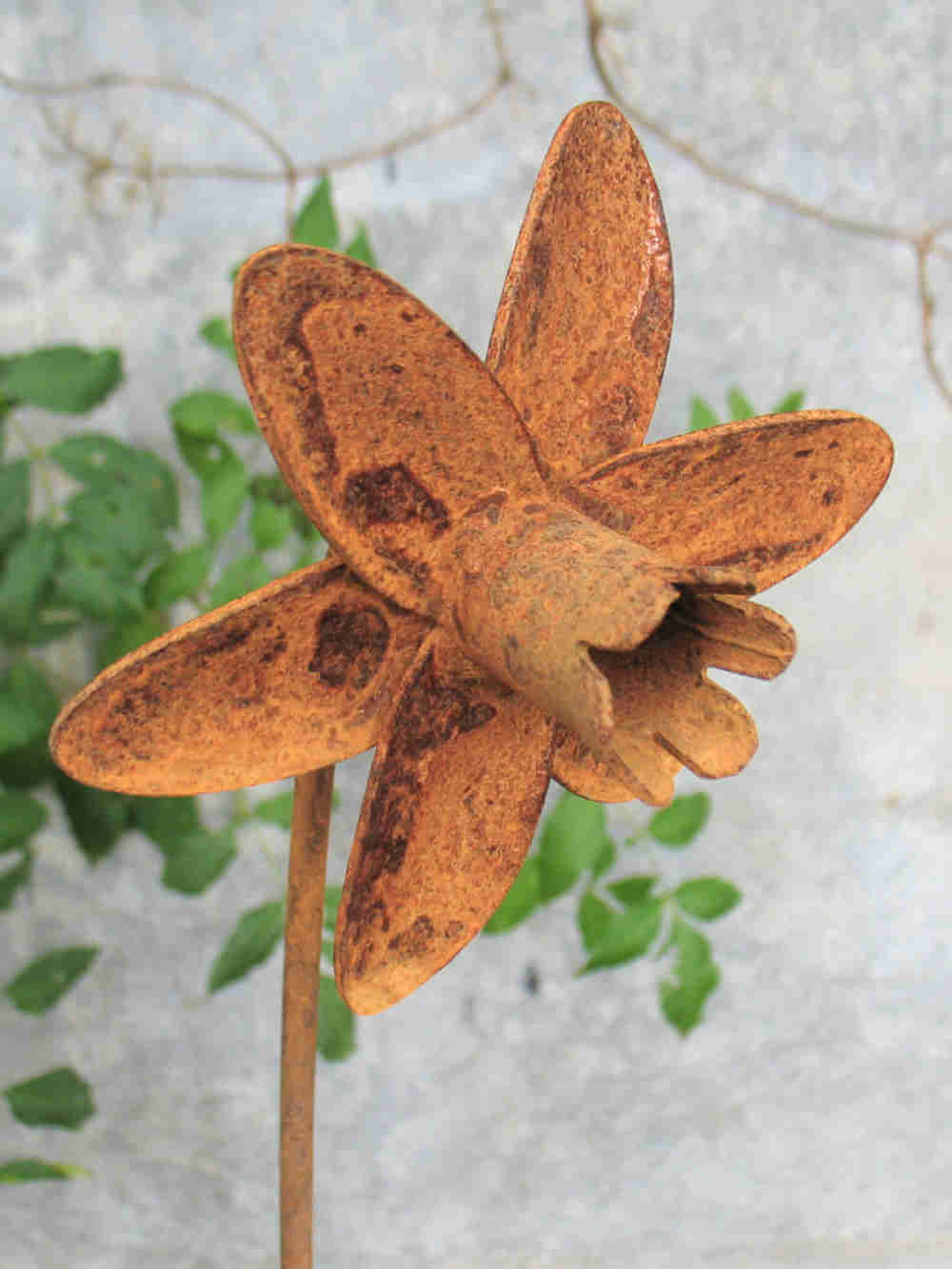 Close up image of a metal Daffodil sculpture showing the mottled rusty patina.
