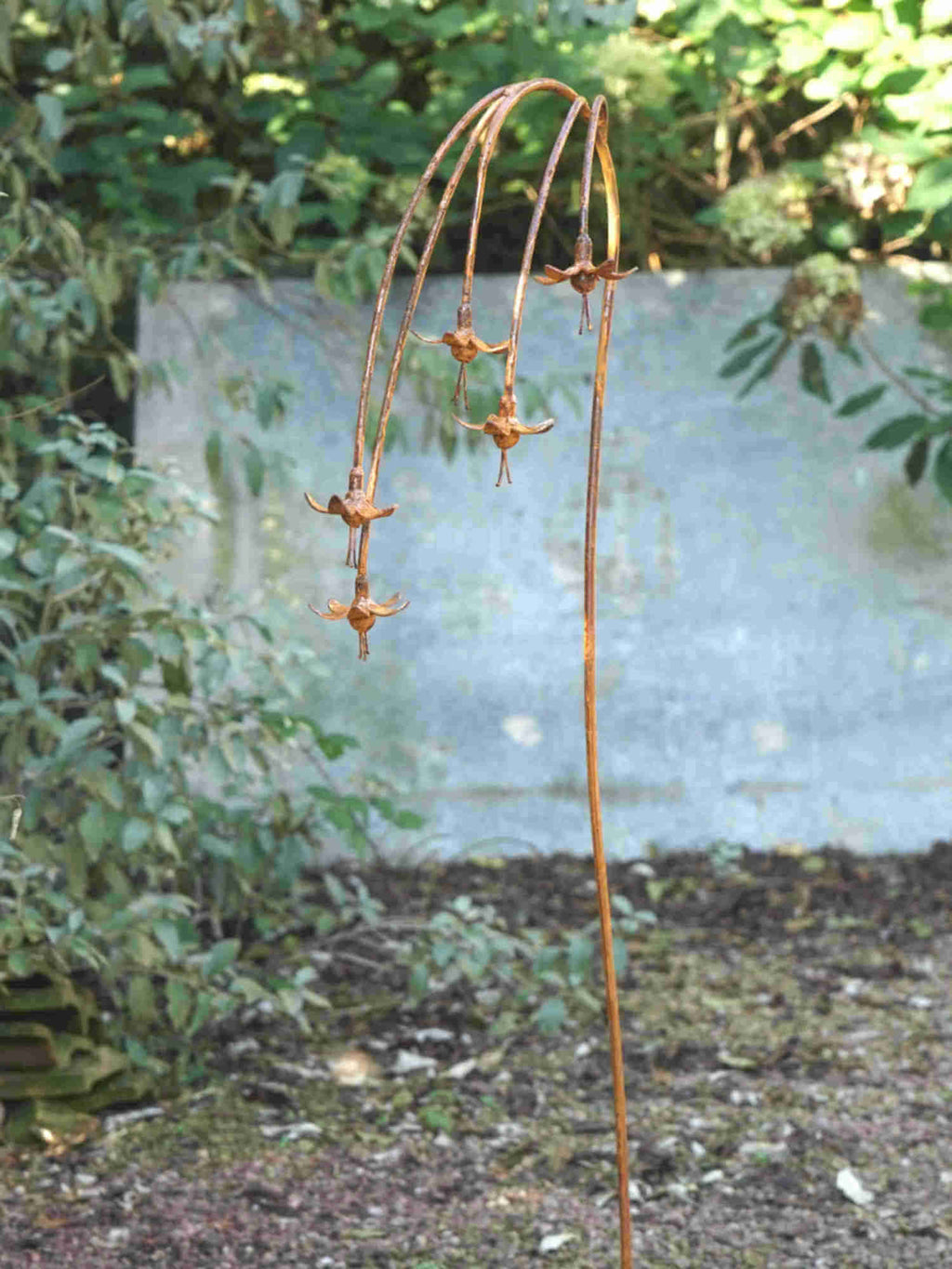 Rusty metal Fuchsias sculpture  in a garden setting