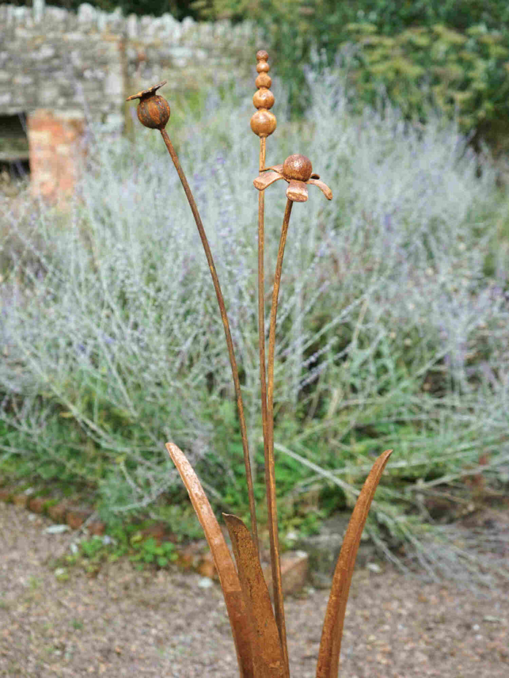 Rusty metal mixed flower sculptures with a blurred garden bacground.