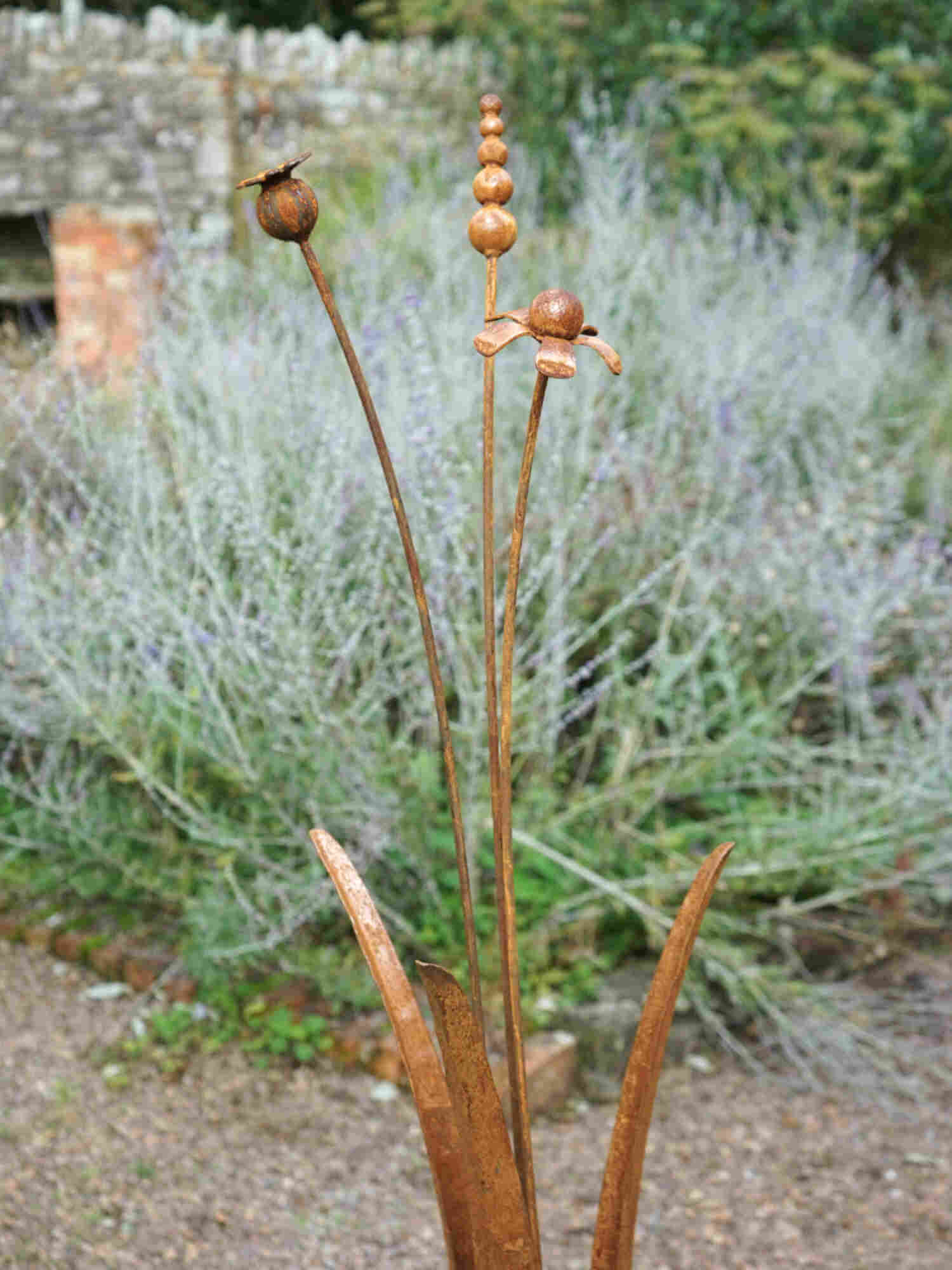 Rusty metal mixed flower sculptures with a blurred garden bacground.