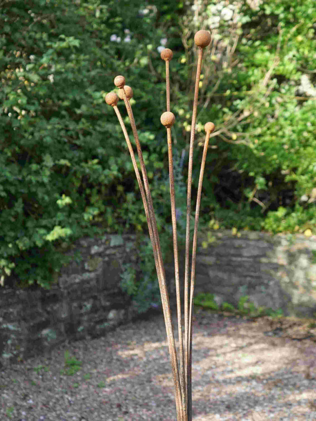Rusty metal Seed Head garden sculpture  against a natural background